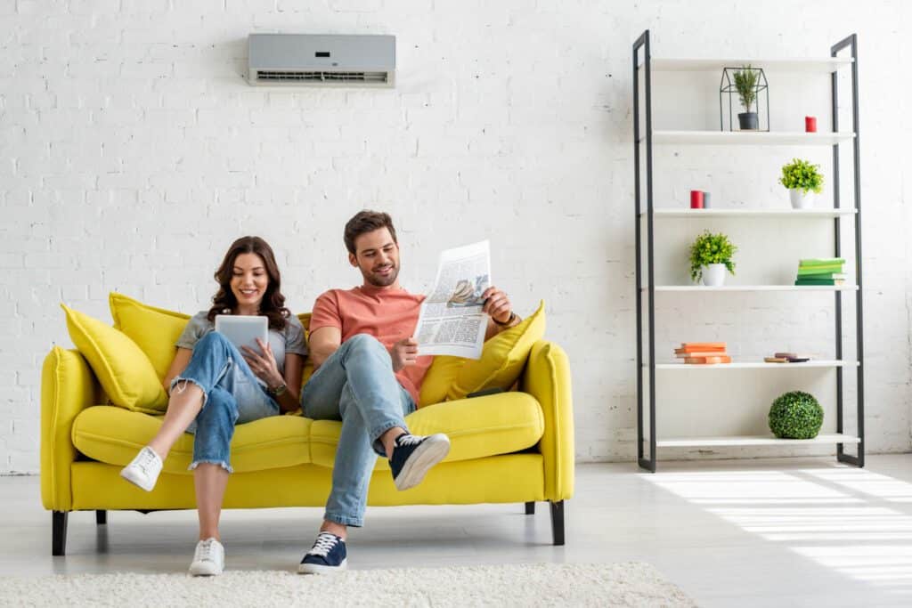 Couple sitting on couch in front of Air conditioning