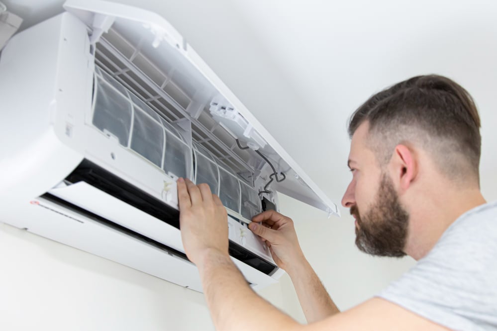 Filter care, technician cleaning filter in a heat pump