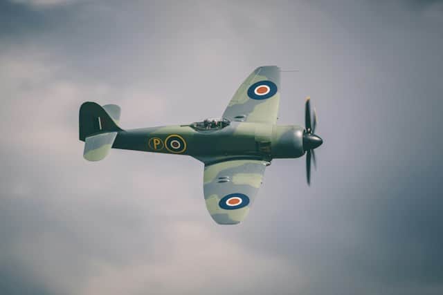 An MKV Spitfire flying with grey clouds in the background
